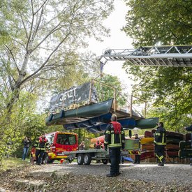 Die Feuerwehr hebt das Festival-Floß mit einer Drehleiter auf einen Anhänger der Feuerwehr.