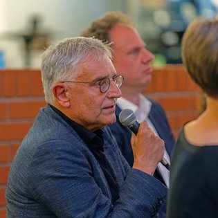 Staatssekretär Arne Braun spricht ins Mikrofon