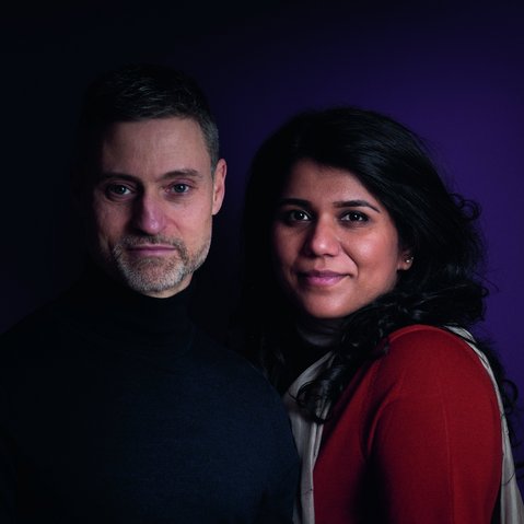 Portrait von Meron Mendel (links) und Saba-Nur Cheema (rechts). Meron Mendel trägt einen dunkelblauen Pulli, hat kurze Haare und einen Bart. Saba-Nur Cheema lehnt sich an seine Seite. Sie hat schwarzes, langes Haar und trägt ein rotes Oberteil.