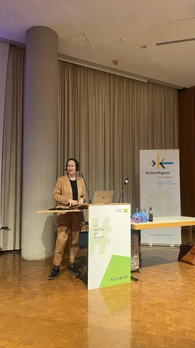 Beate Lex, Direktorin des Staatlichen Museums für Naturkunde Stuttgart, hält einen Vortrag an einem Rednerpult in einem Raum der KulturRegion Stuttgart.