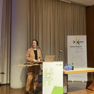 Beate Lex, Direktorin des Staatlichen Museums für Naturkunde Stuttgart, hält einen Vortrag an einem Rednerpult in einem Raum der KulturRegion Stuttgart.