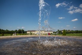 Blick auf das Schloss. Im Vordergrun ein Springbrunnen.