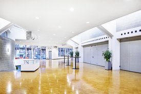 Innenansicht auf das Foyer. Die Wände sind in hellen Tönen gehalten, das Foyer verfügt über einen Parkettboden.