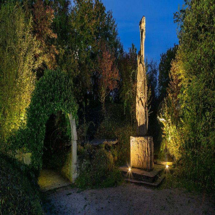 Blick auf das beleuchtete Friedensdenkmal bei Nacht.