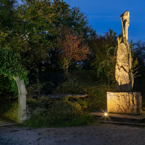 Blick auf das beleuchtete Friedensdenkmal bei Nacht.