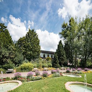 Blick auf die Stadthalle vom Park aus bei leicht bewölktem Himmel