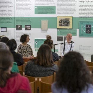 Die Gruppe der Teilnehmer*innen der Bustour als Publikum beim Salon von Michael Turinsky. 