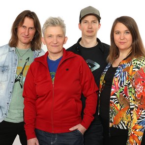Bild von Suli Puschban und den drei Bandmitgliedern vor einem weißen Hintergrund.