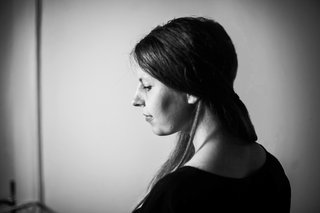 Die Schwarz Weiß Aufnahme zeigt eine blonde Frau schaut seitlich und lächelnd leicht