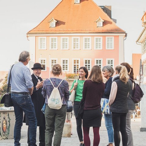 Stadtführung in Schorndorf vor Fachwerkgebäuden und einem Brunnen