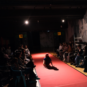 Performance auf einem roten Teppich, rechts und links davon sind Zuschauer zu sehen. Im Hintergrund steht das Soundsystem der KulturRegion Stuttgart.