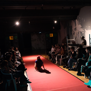 Performance auf einem roten Teppich, rechts und links davon sind Zuschauer zu sehen. Im Hintergrund steht das Soundsystem der KulturRegion Stuttgart.