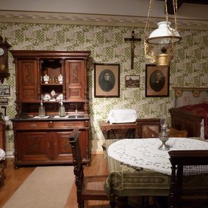 Blick in die Ausstellung. Es ist unter anderem eine Anrichte, ein Tisch mit Stühlen und ein Sofa zu sehen
