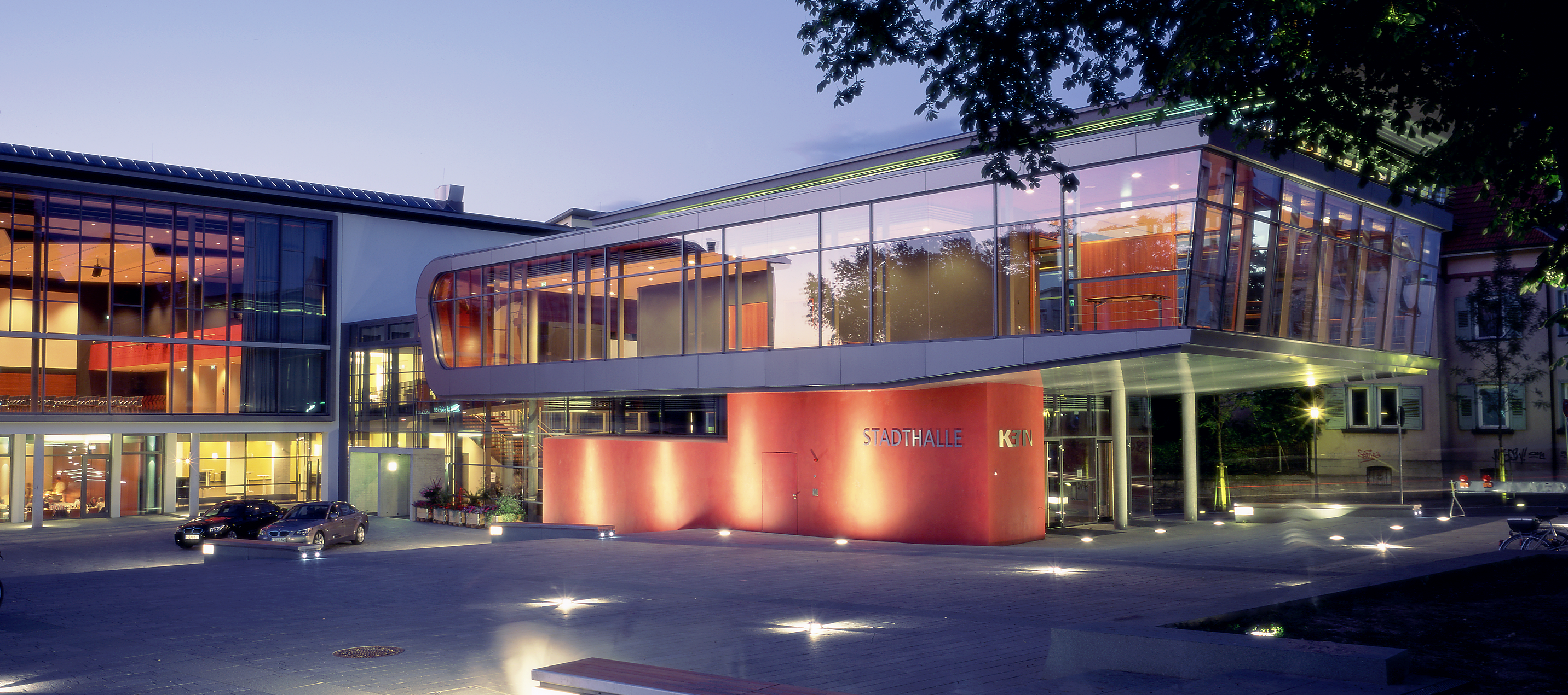 Blick auf die effektvoll beleuchtete Stadthalle bei Dunkelheit