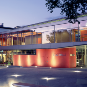 Blick auf die effektvoll beleuchtete Stadthalle bei Dunkelheit