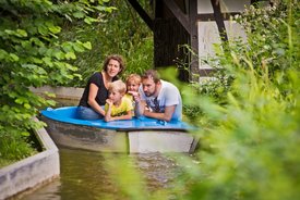 Eine Familie fährt in einem Boot im Märchengarten