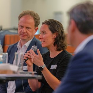Isabel Schwab sitzt neben Dr. Matthias Knecht und spricht ins Mikrofon