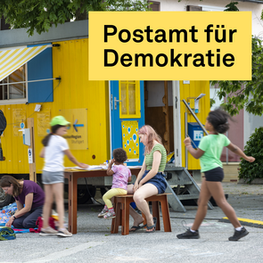 Menschen sitzen und spielen vor einem gelben mobilen Wagen mit der Aufschrift »KulturRegion Stuttgart«. Eine Frau liest auf einem Liegestuhl, Kinder laufen und spielen, eine andere Frau schreibt etwas an einem Tisch. Der Wagen hat eine gelb-weiß gestreifte Markise, blaue Fensterläden und Plakate an der Wand. Im Vordergrund steht ein großes gelbes Banner mit der Aufschrift »POSTAMT FÜR DEMOKRATIE«.