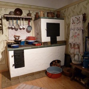 Blick in die Ausstellung: es ist eine alte Kücheneinrichtung mit einem Holzherd und einem Holzbackofen zu sehen