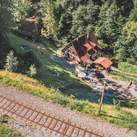 Blick von den Gleisen auf das Gebüder der Klingenmühle. In einer Schlucht am Wald gelegen.