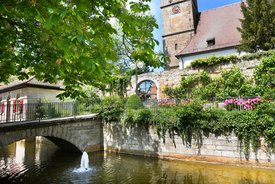 Naturaufnahme am Kirchplatz in Echterdingen. Ein kleiner Bach und eine Brücke sind zu sehen.