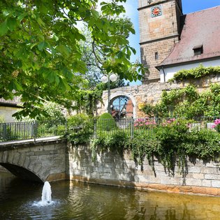 Naturaufnahme am Kirchplatz in Echterdingen. Ein kleiner Bach und eine Brücke sind zu sehen.