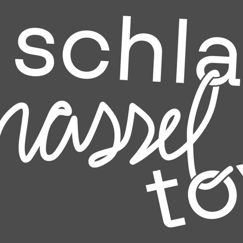 Schriftzug Schlamassel-Tov auf grauem Hintergrund.