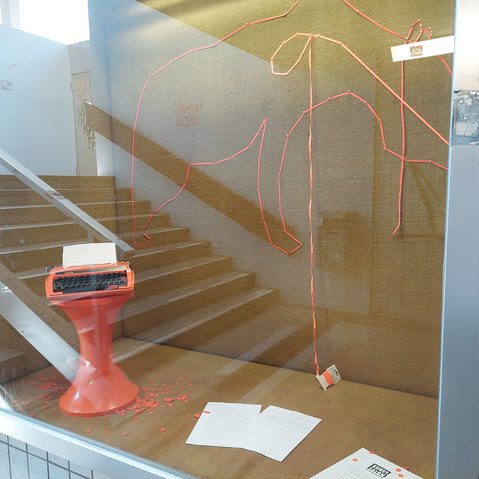 Ein Schaufenster in einer Unterführung in dem Kunst gezeigt wird.