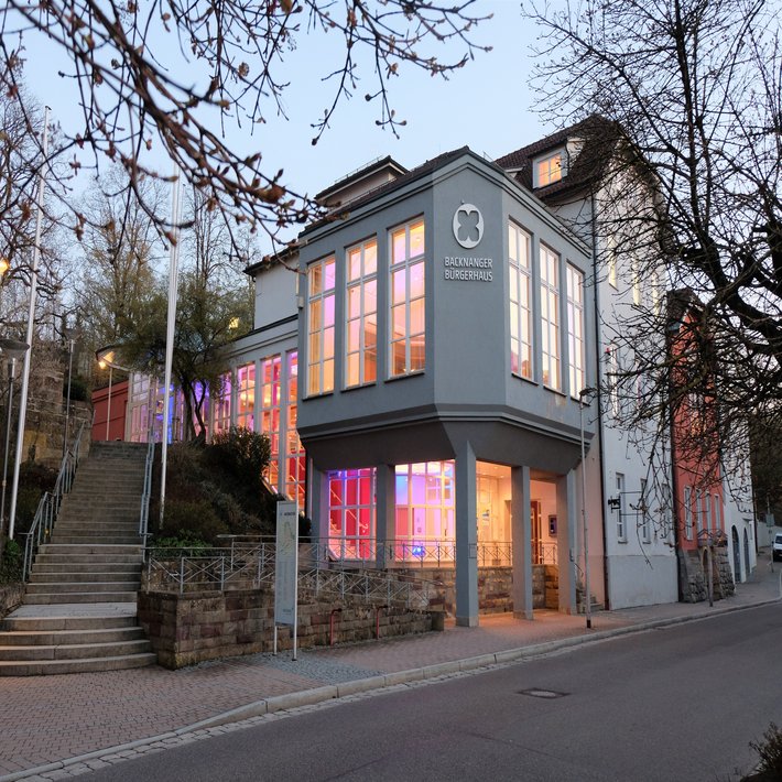 Aussenansicht Bürgerhaus in der Dämmerung. Innen ist das Bürgerhaus bunt beleuchtet.