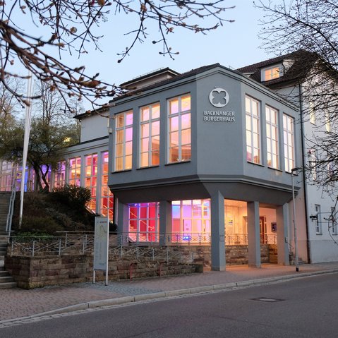 Aussenansicht Bürgerhaus in der Dämmerung. Innen ist das Bürgerhaus bunt beleuchtet.