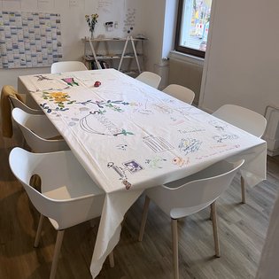 Tisch in der Geschäftsstelle der KulturRegion. Der Tisch ist mit einem Stoff bespannt, der bemalt und beschrieben wurde.