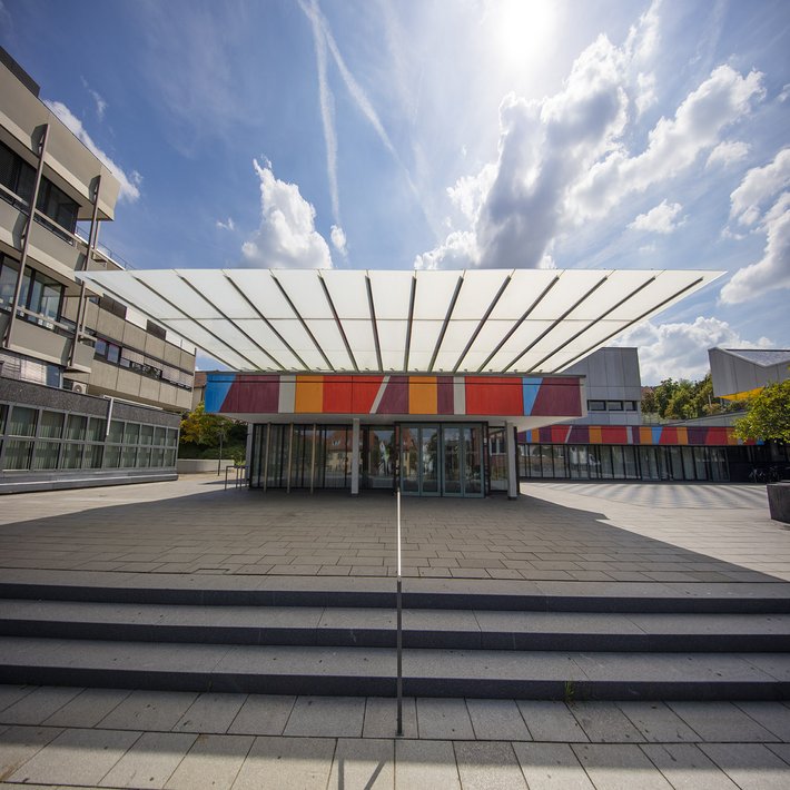 Aussenansicht Stadthalle, Blick auf den bunt gestalteten Eingangsbereich bei strahlendem Sonnenschein