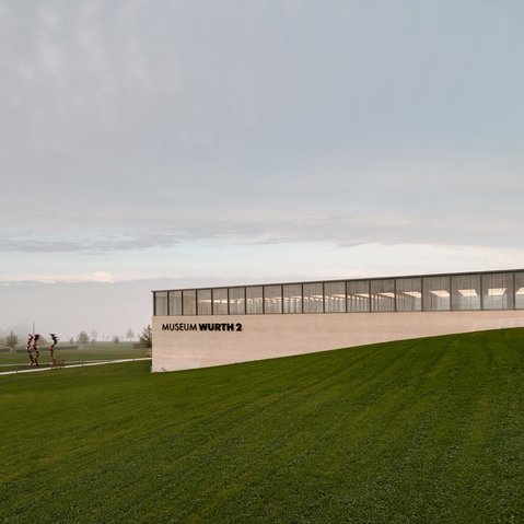 Blick über eine Wiese auf das sehr morderne Gebäudes des Museums