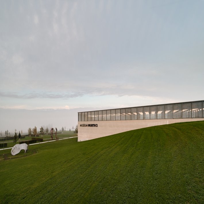 Blick über eine Wiese auf das sehr morderne Gebäudes des Museums