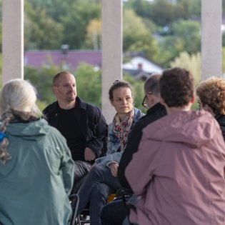 Im Vordergrund sitzen Zuhörer*innen, die von hinten zu sehen sind. Dahinter Michael Turinsky und Anke Hofmann beim Salon in Marbach.