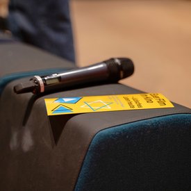 Ein Mikrofon und ein Flyer des Projektes »Euer Film im Kino« liegen auf einer Stuhllehne.