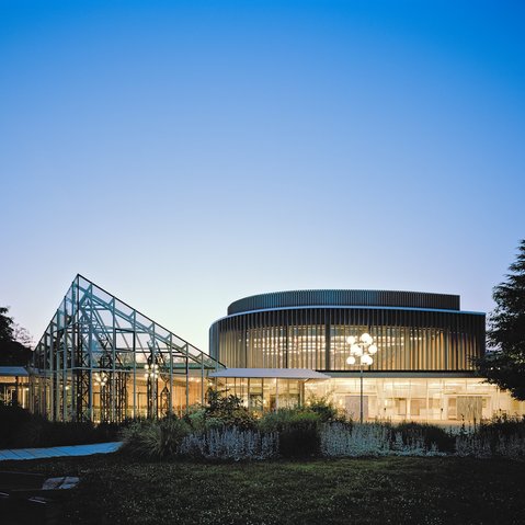 Aussenansicht auf die Stadthalle bei Nacht.