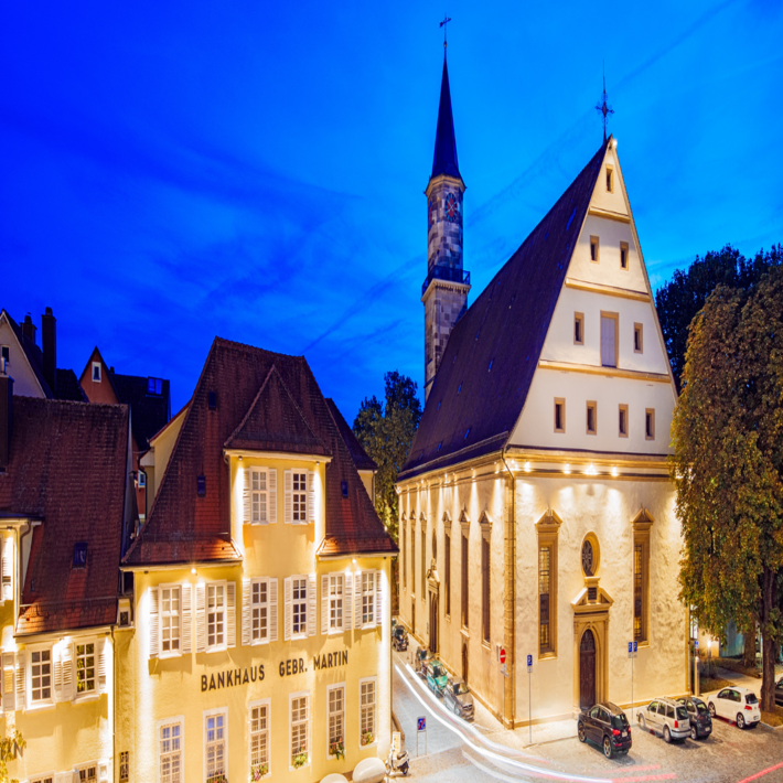 Blick auf die evangelische Stadtkirche bei Nacht. Alle Gebäude sind beleuchtet.