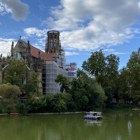 Das Festival-Floß auf dem Feuersee in Stuttgart-West. Im Hintergrund ist die eingerüstete Johanneskirche zu sehen.