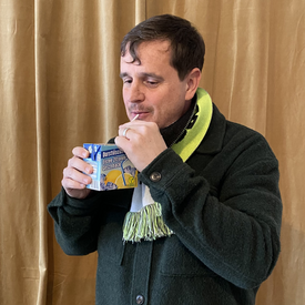 Moderator Ingmar Volkmann während der Aufnahme des Podcast. Mit einem Strohhalm trinkt er einen typischen Tetra-Pack-Schuldrink.