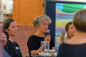 Dr. Birte Werner spricht ins Mikrofon und gestikuliert mit offener Hand