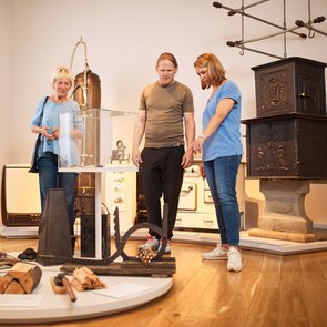 Blick in die Ausstellung: Mehrere Personen betrachten ein Objekt.