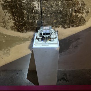 Ein elektronisches Kunstwerk von Fabian Kühfuß auf einem Podest wird bei einem Symposium in Stuttgart ausgestellt.