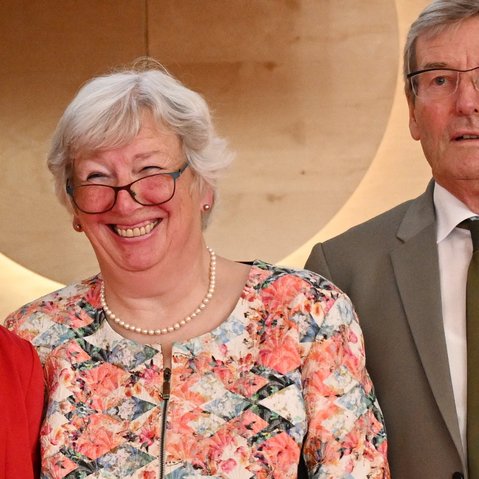 Bild von Dorothee Kraus-Prause, Ingrid Grischtschenko und Thomas Bopp, vor einem beige-braunen Hintergrund. Die drei Personen stehen nah beieinander und lächeln in die Kamera. Das Bild ist bei der Verabschiedung aus der Regionalversammlung entstanden.