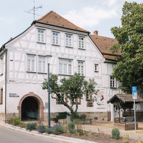 Blick auf das Fachwerkgebäude des Stadtmuseums, Im Vordergrund ein überdachter Brunnenschacht