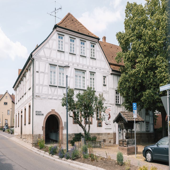 Blick auf das Fachwerkgebäude des Stadtmuseums, Im Vordergrund ein überdachter Brunnenschacht