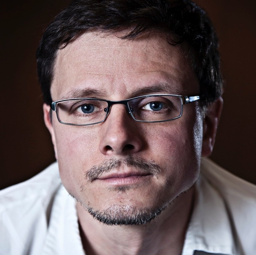 Portrait von Hannes Hartmann. Er hat dunkles Haar und trägt eine Brille.