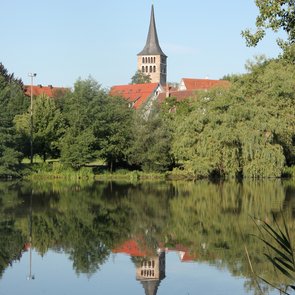 Aussenansicht der Kirche über den See hinweh fotografiert.