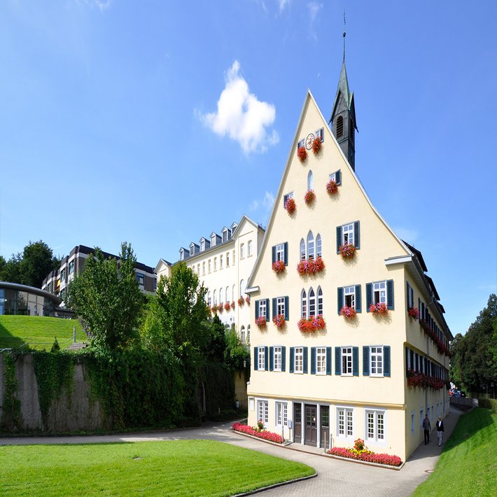 Aussenansicht Altes Badhaus. Im Hintergrund blauer Himmer mit einer kleinen Wolke.