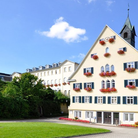 Aussenansicht Altes Badhaus. Im Hintergrund blauer Himmer mit einer kleinen Wolke.